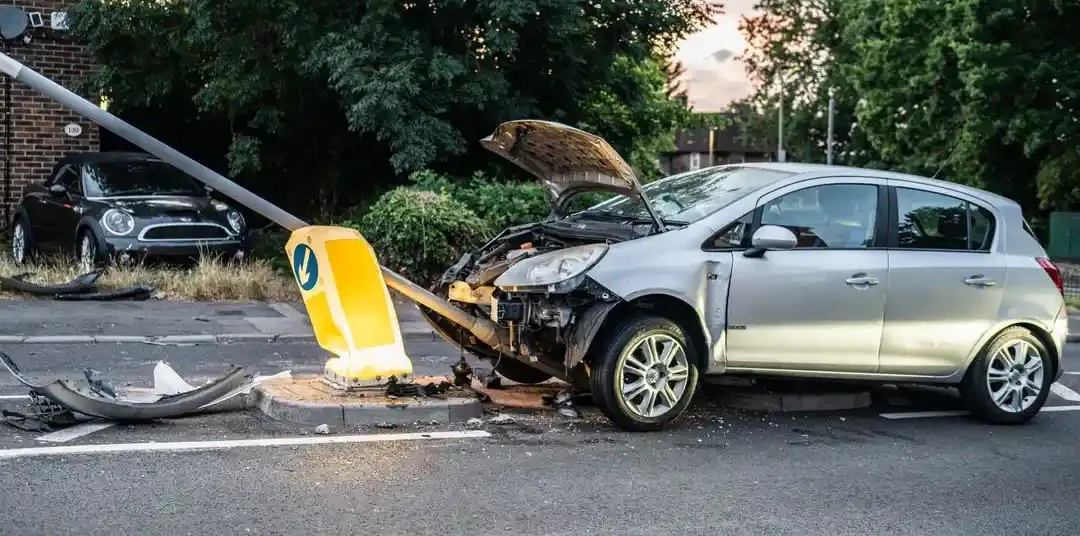 A damaged car that crashed into a lamp post on a London street during twilight